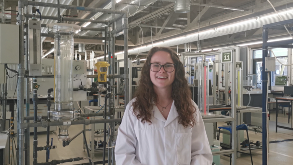 A student in an industrial lab smiling to camera